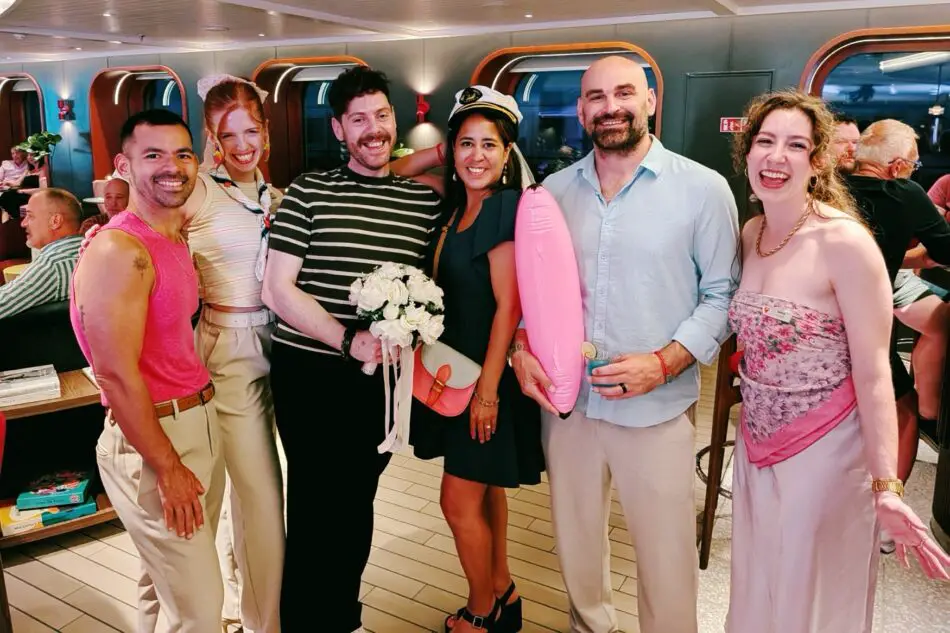 Group of people posing for a photo aboard a Virgin Voyages cruise ship during an event