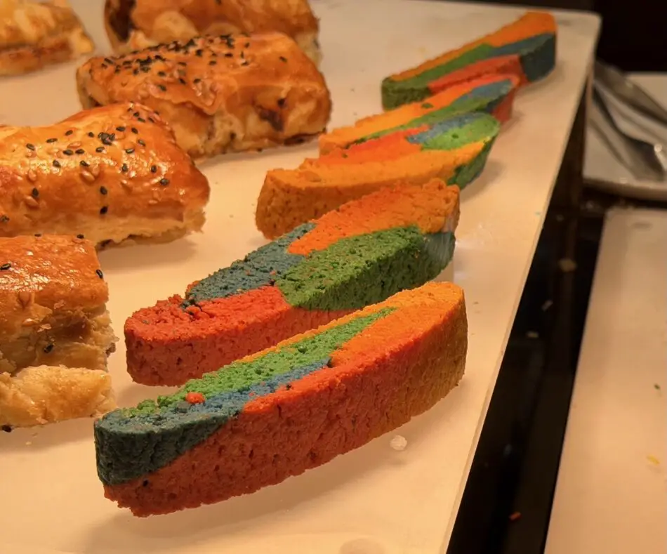 Rainbow colored loaf cake slices on a white platter