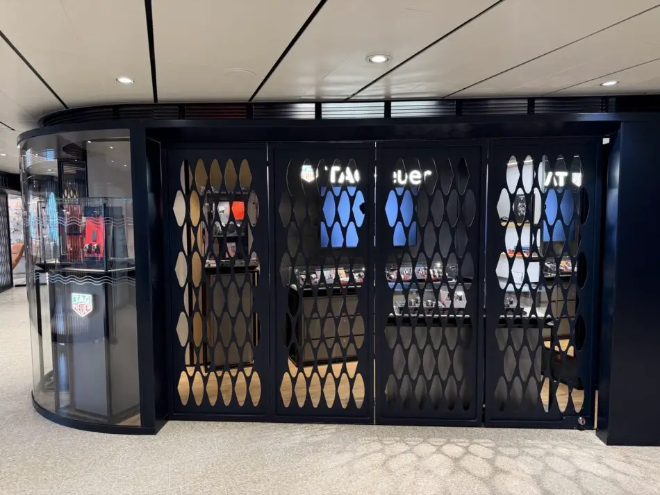 Dark blue boutique with lattice doors housing watch displays