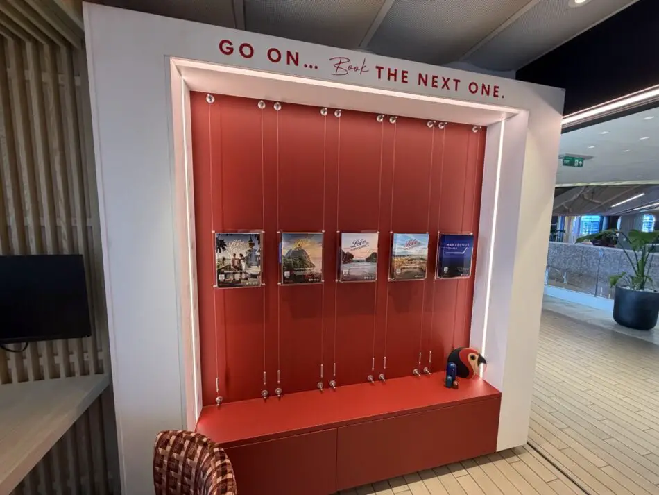 Virgin Voyages promotional display with red backdrop and posters