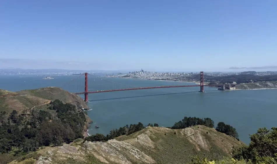 Golden Gate Bridge crossing a blue bay with San Francisco skyline