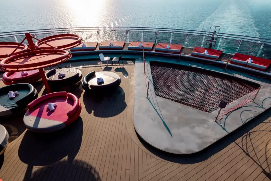 Outdoor cruise ship deck with colorful circular daybeds and ocean view