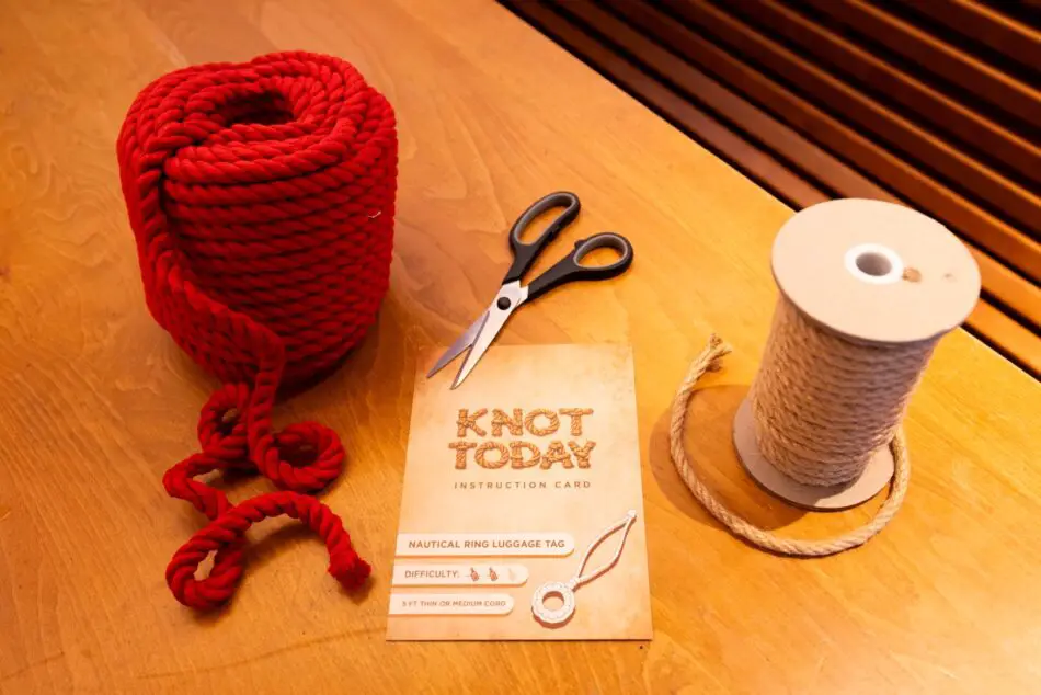 Red rope, scissors, and Knot Today instruction card in a Virgin Voyages cabin