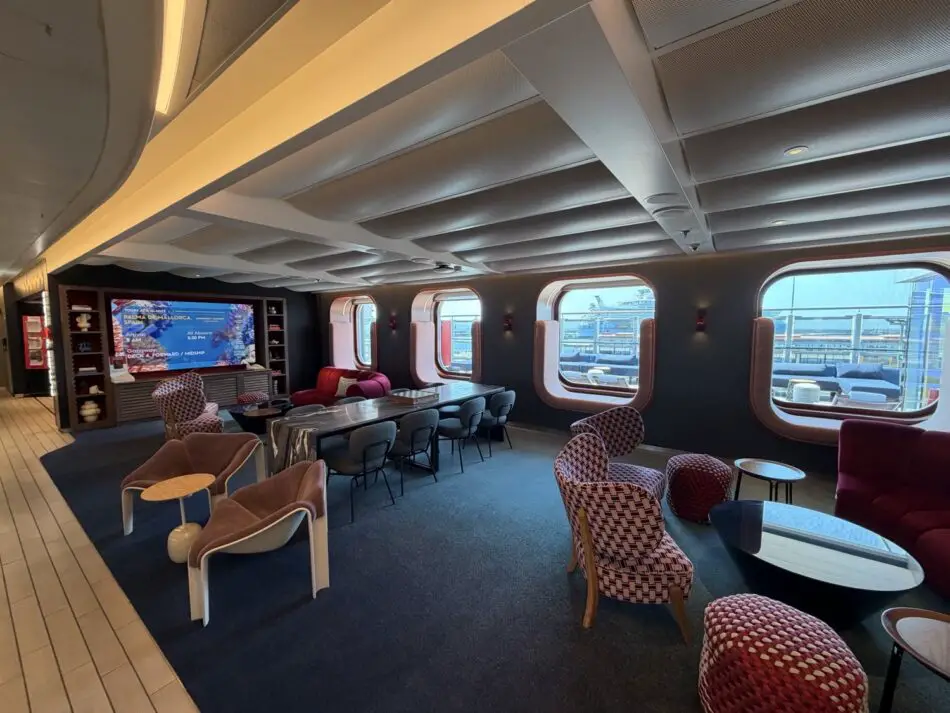 Luxurious cruise ship lounge with curved windows and plush seating on a Virgin Voyages ship