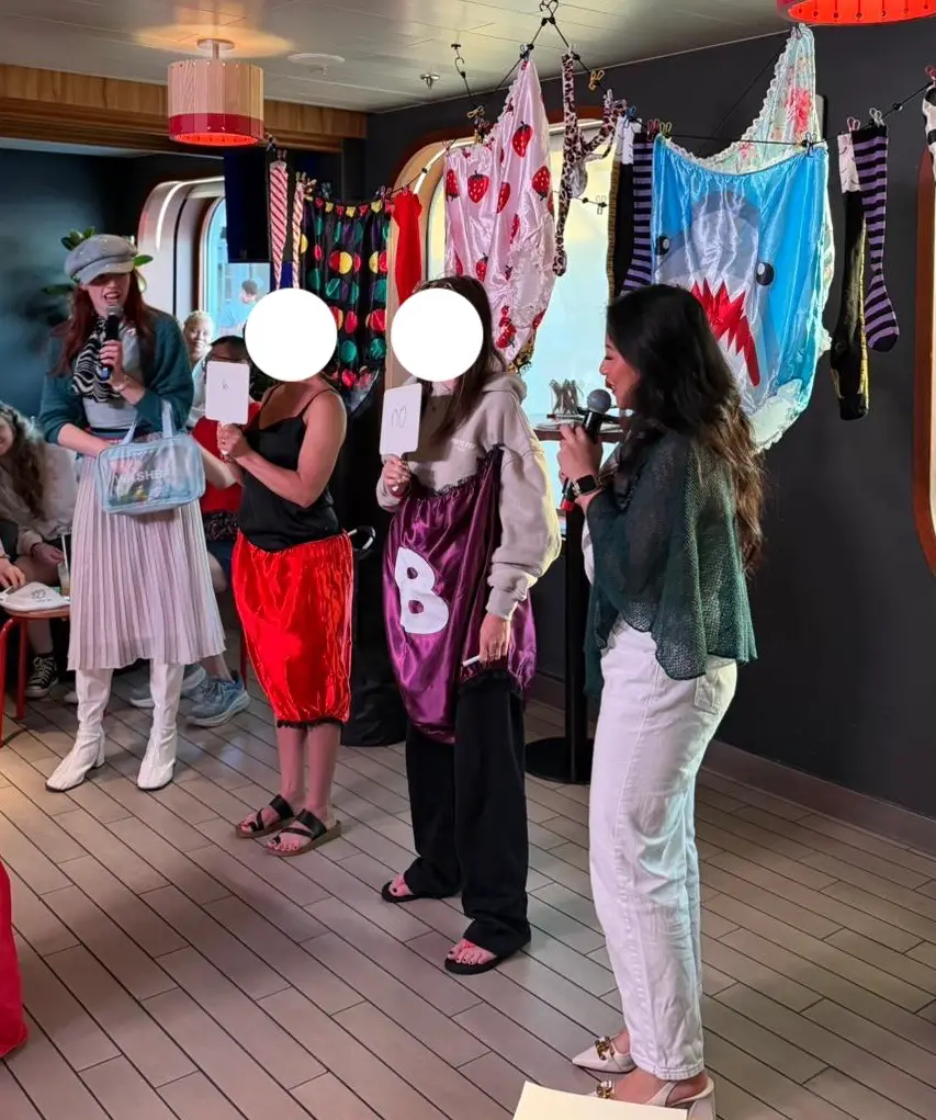 Group of costumed guests performing in a Virgin Voyages cruise ship cabin
