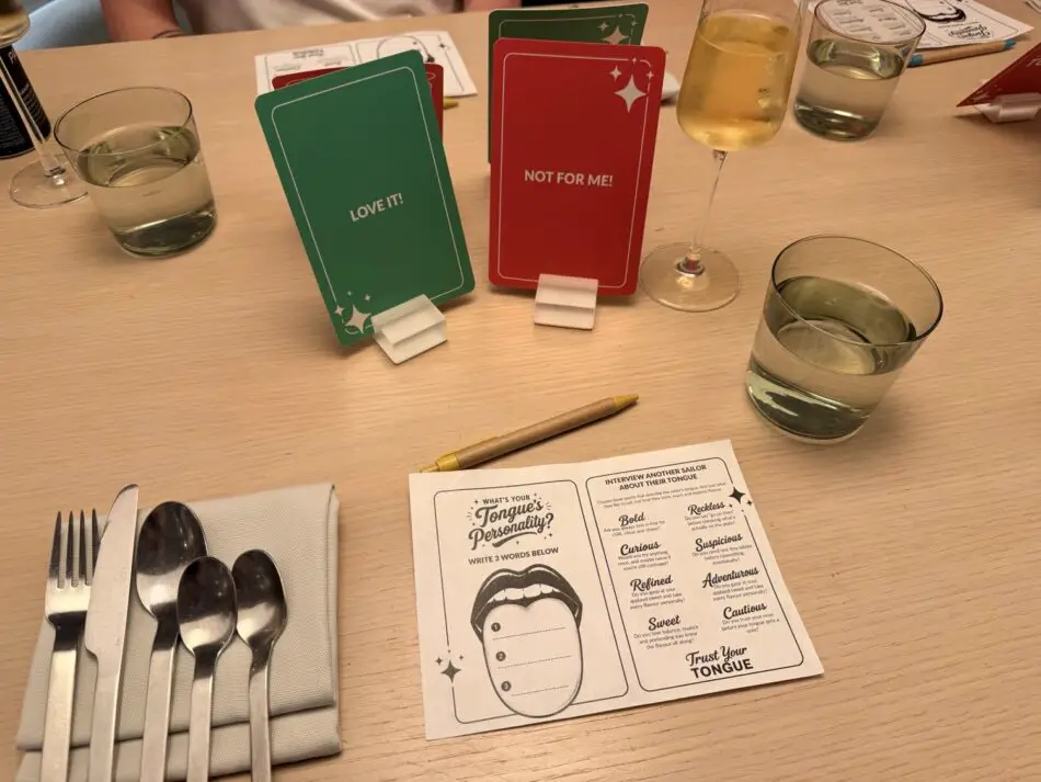 On a Virgin Voyages cruise ship table, green Love It and red Not For Me cards with utensils and glasses
