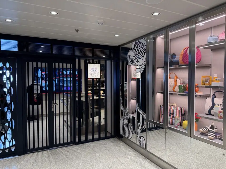Interior of a Virgin Voyages cruise ship boutique with handbags on glass shelves
