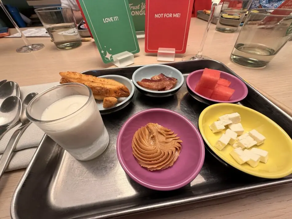 Assorted snacks on a metal tray in a Virgin Voyages cruise ship cabin