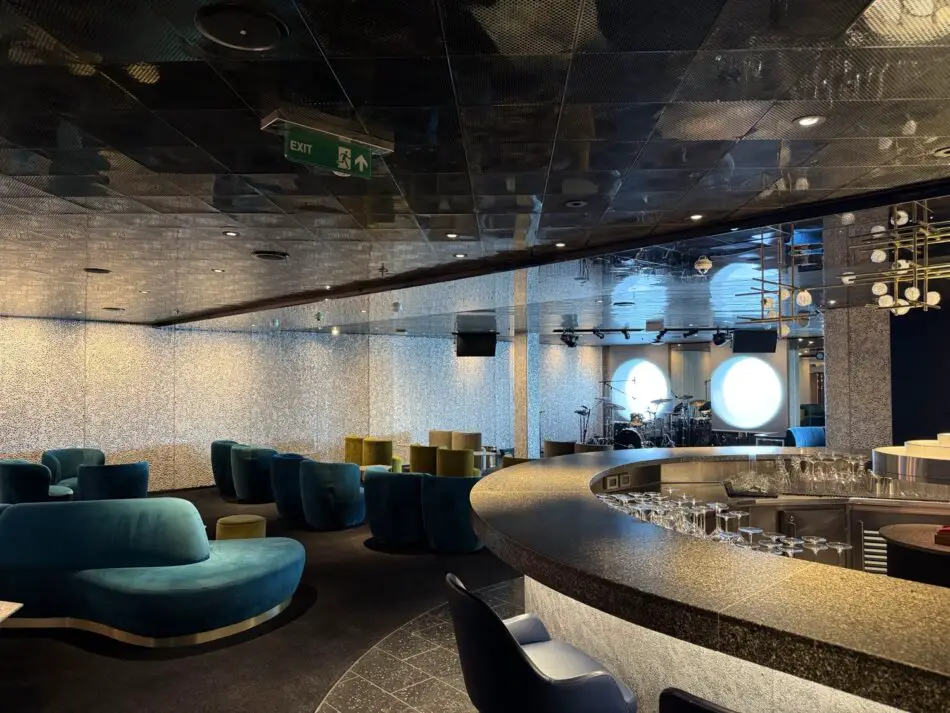 Lounge on a Virgin Voyages cruise ship with curved bar and stage