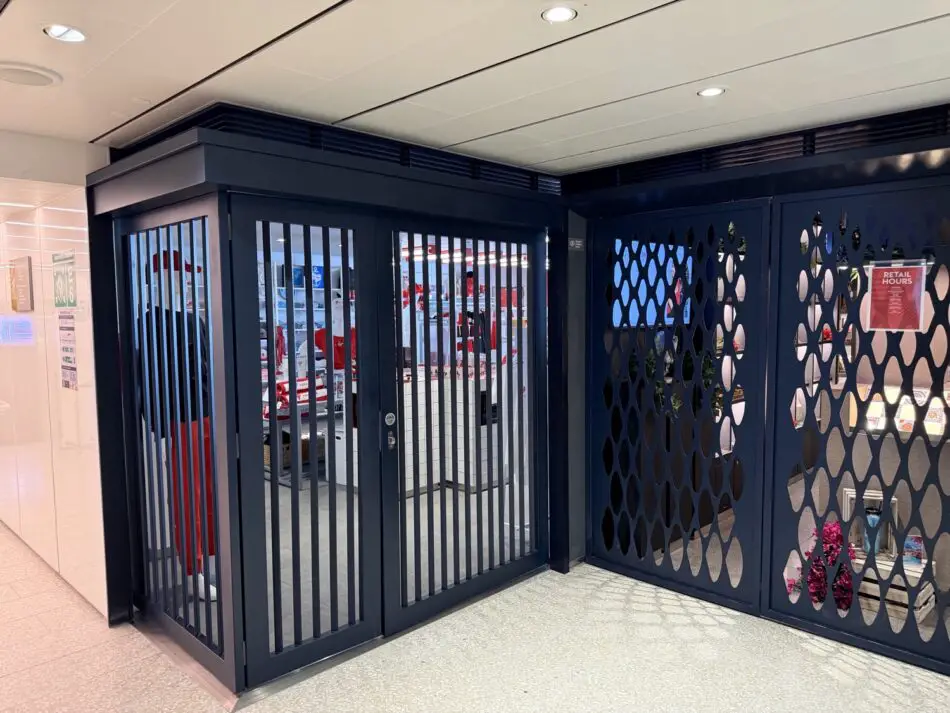 Cruise ship retail area with blue metal gates and decorative lattice panels