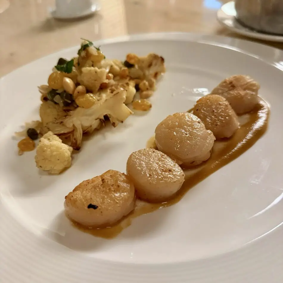 Seared scallops with brown sauce and a cauliflower and chickpea crumble