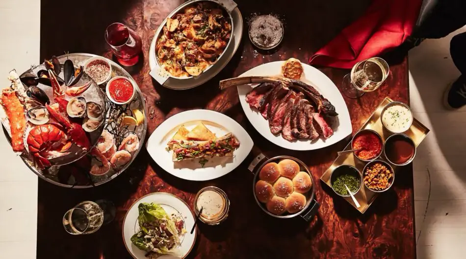 Overhead view of a seafood and steak feast on a wooden table