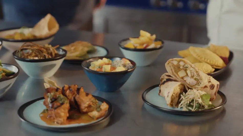 Assorted small dishes served in bowls on a stainless steel counter