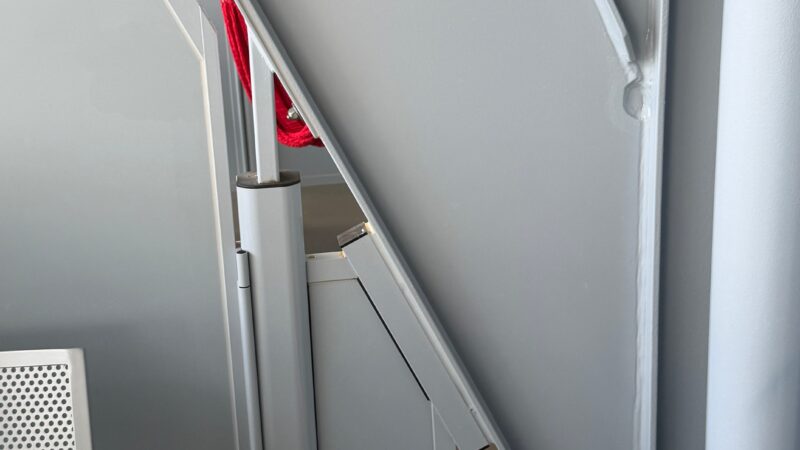 A Virgin Voyages cruise ship cabin balcony with a metal divider and part of a modern chair.