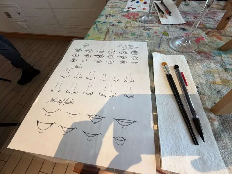 Sheet with numerous eye sketches and mouth shapes on a painting table