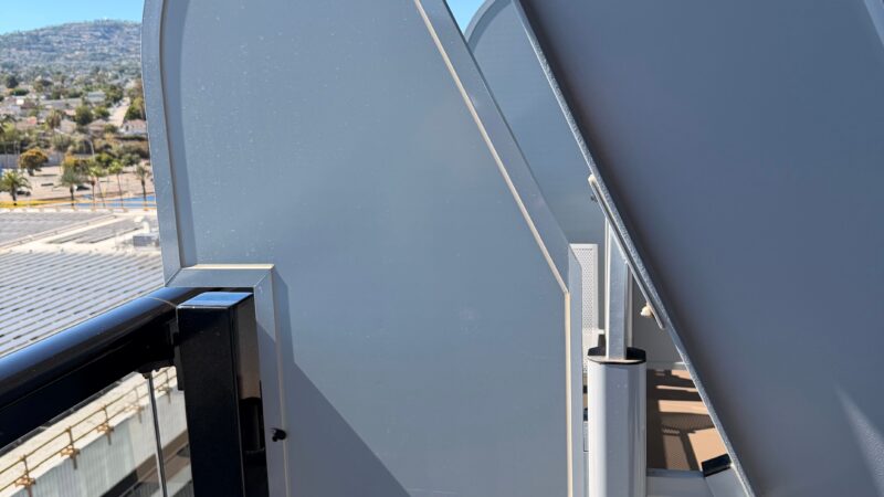 View from a Virgin Voyages cruise ship balcony, showing metal panels and an outdoor chair.