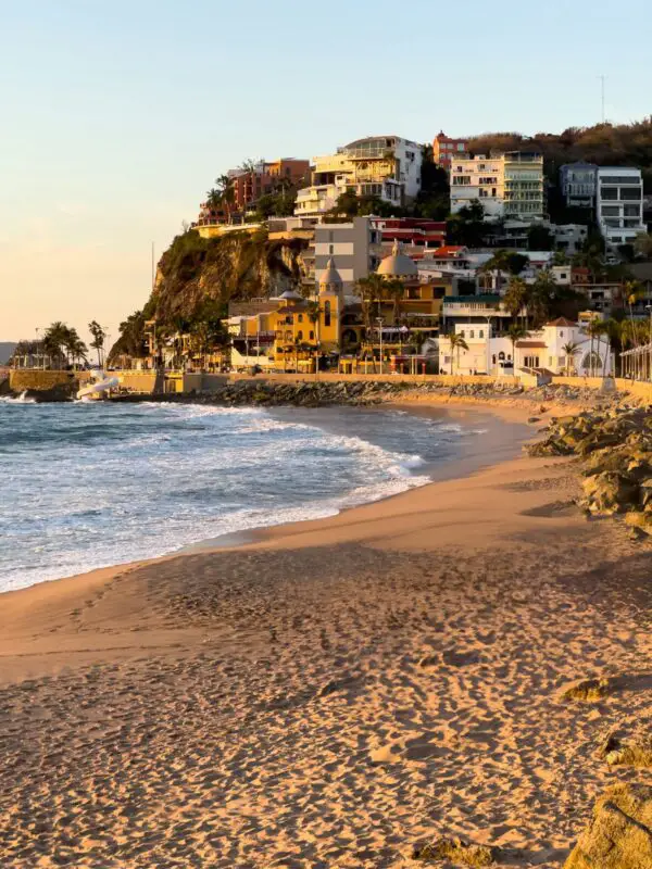 Sandy beach and hillside buildings in Mazatlán, Mexico